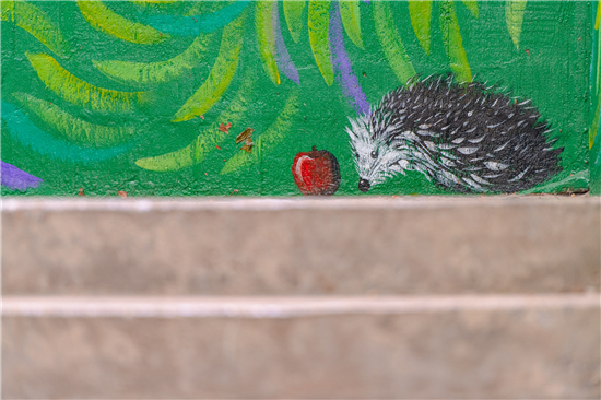 Painting of a hedgehog eating an apple