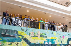 All attendees from the Dental School Roundtable stand together above a mural of Bristol in the Trinity Quay Campus for University of Bristol 