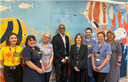 Representatives from Bristol & Weston Hospitals Charity, Bristol NHS Group and the nursing team stand together in front of aquatic creatures on a wall