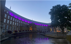 Bristol City Hall at dusk, with purple lights along the roof