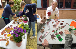 A collage of three images showing a nature-based craft activity. In the left image, two people stand beside a table outdoors arranging fallen leaves, small objects and potted flowers including purple blossoms, with various seasonal foliage spread across a white tablecloth. In the top-right image, a person leans forward holding a handmade red flower decoration, with a wooden bench and building wall behind. In the bottom-right image, several hands are visible around a table indoors, assembling dri