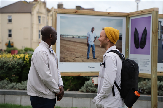 In Our Hands Exhibition Weston General Hospital staff member Gideon (l) next to his portrait with photographer Paul Blakemore.credit Lou Taylor